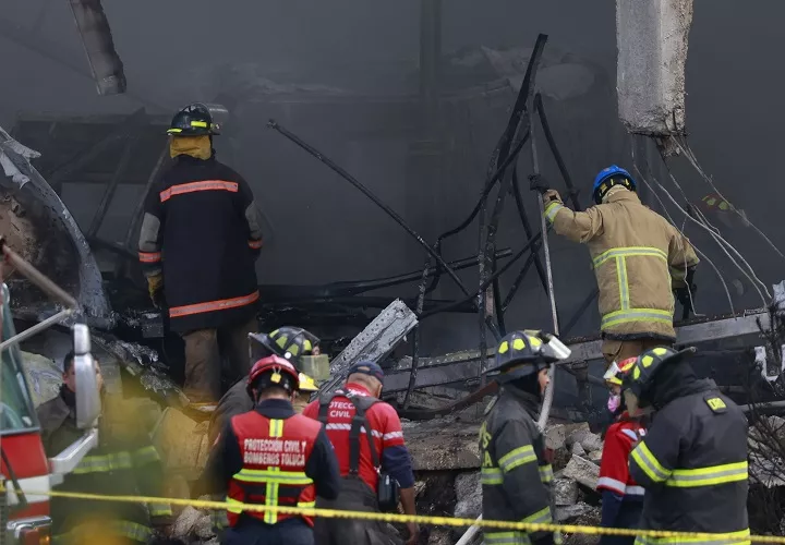 Integrantes de Protección Civil y bomberos trabajan en la bodega industrial donde cayó una avioneta Cessna Citation 650 este lunes, en el municipio de San Mateo Atenco, en el estado de México. Foto. EFE 