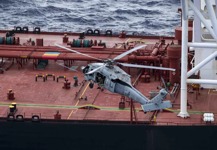 Fotografía difundida en la cuenta oficial en X @DeptofWar del Departamento de Guerra de Estados Unidos de uno de sus helicópteros interceptando un buque petrolero en el océano Índico. 
