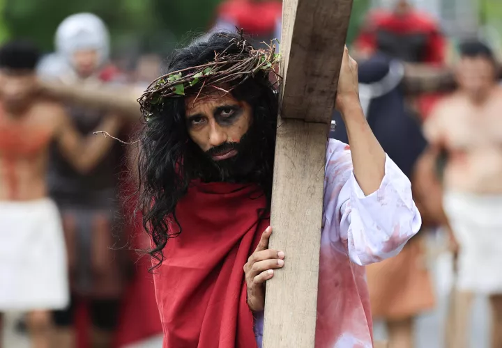  Una persona representa la crucifixión de Jesús durante el viacrusis de Semana Santa este viernes