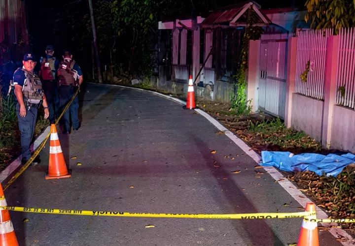 Escena del homicidio de un joven tras una riña en Barrio Conejo, Almirante, Bocas del Toro, con presencia policial y área acordonada.