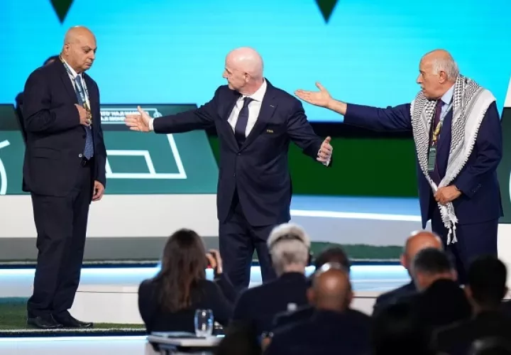 El presidente de la Asociación de Fútbol Palestina Jibril Rajoub (der.) se rehúsa a darle la mano al presidente de la Asociación de Fútbol de Israel Basim Sheikh Suliman (izq.) junto al presidente de la FIFA, Gianni Infantino durante el 76mo Congreso de la FIFA , en Canadá. Foto: EFE