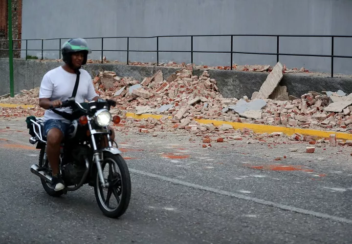 Un motociclista transita cerca de escombros este miércoles, en Caracas (Venezuela). Un terremoto de magnitud 7,1 registrado en el noroeste de Montalbán, en el centro de venezuela, se sintió en gran parte del país. Foto. EFE