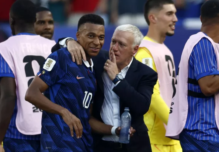 El seleccionador francés, Didier Deschamps, calma a Kylian Mbappé tras culminar el partido frente a Paraguay. /Foto: EFE