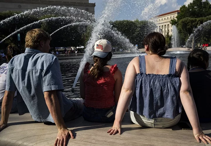 Personas se refrescan en la fuente del Jardín de Esculturas de la Galería Nacional de Arte, en el National Mall de Washington, DC (EE.UU.), durante temperaturas de calor extremo. Foto. EFE