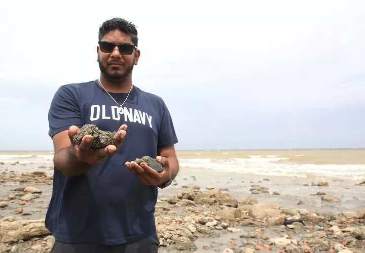El estudiante de la Universidad de Trinidad y Tobago Joshua Jadoo mostrando fragmentos de piritas surgidos por los terremotos de Venezuela en Cedros. Foto. EFE