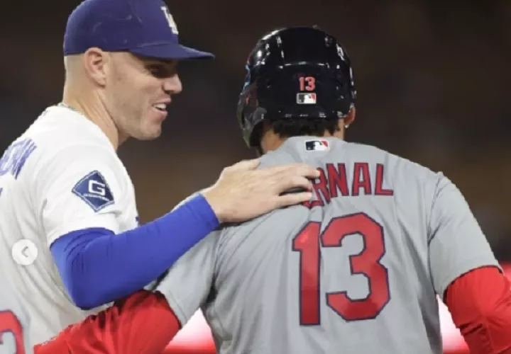 Leonardo Bernal es felicitado por el primera base de los Dodgers, Freddie Freeman, luego de haber conectado su primer hit en Grandes Ligas.