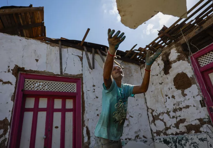 Un hombre trabaja en la demolición de una casa de quincha, luego del terremoto de magnitud 7,7 en La Villa de Los Santos. /Foto: EFE