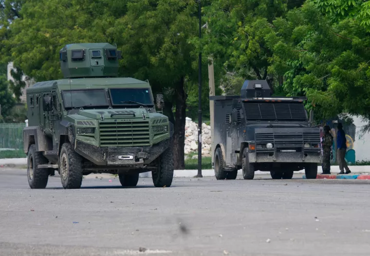 Policías haitianos vigilan en una calle mientras continúa la búsqueda de cuatro militares salvadoreños integrantes de la Fuerza de Supresión de Pandillas. /EFE